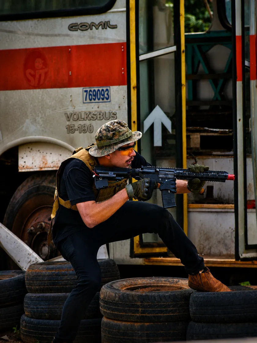 Jogador avançando entre pneus e ônibus no cenário da StrikeZone
